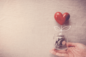 Charitable donations change jar with a heart on top