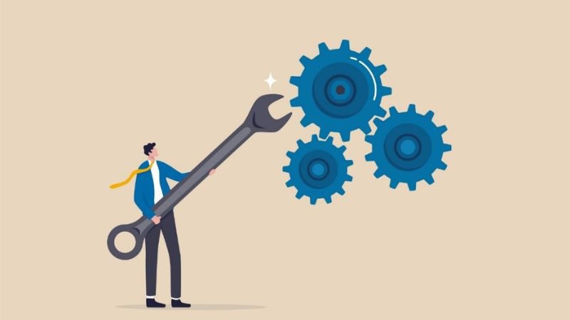 vector image of a man holding a giant wrench up to large cogs